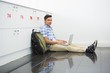 © WavebreakmediaMicro - Smiling college student sitting on the floor with laptop