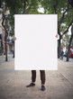 Man with blank poster on a street
