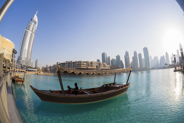 Wall Mural - Dubai lagoon with boat against sunset in UAE