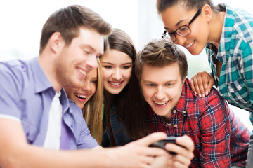 Canvas Print - students looking at smartphone at school