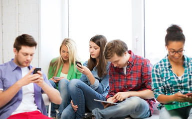 Wall Mural - students looking into devices at school