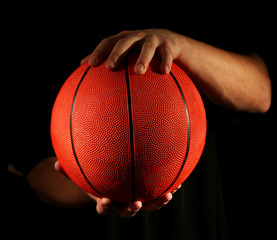 Wall Mural - Basketball player holding ball, on dark background