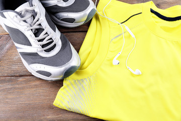 Canvas Print - Sport shoes and clothes on wooden background