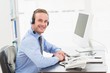 © WavebreakmediaMicro - Smiling businessman speaking with headset