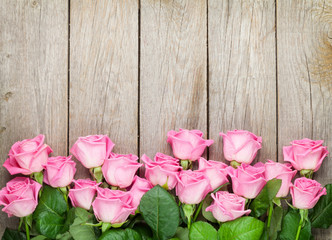 Wall Mural - Valentines day background with pink roses over wooden table