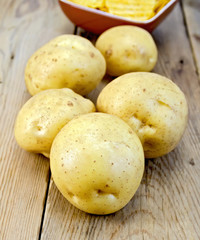 Poster - Potatoes yellow and chips on wooden board