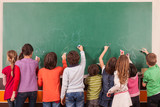 Fototapeta  - Group of nine children drawing on school chalkboard with chalks.