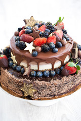 Chocolate cake with icing, decorated with fresh fruit