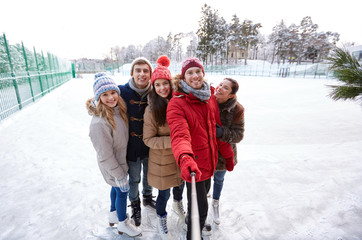 Poster - happy friends with smartphone on ice skating rink