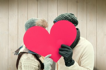 Poster - Attractive young couple in warm clothes holding red heart
