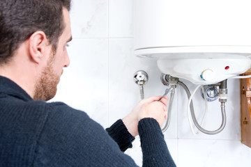 Plumber fixing electric water heater