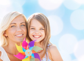 Canvas Print - happy mother and little girl with pinwheel toy