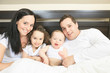 © Louis-Photo - Young family resting together in parent's bed