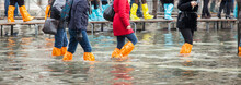 Close Up Of Legs With Boots Due To The High Water In Venice.