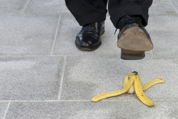 Businessman about to step on a banana skin