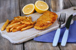 Breaded fried fish fillet and potatoes with sliced lemon and