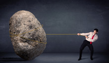 Businessman Pulling Huge Rock With A Rope