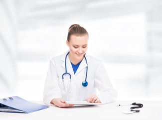 Wall Mural - Young, professional and cheerful female doctor in the office