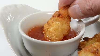 Canvas Print - Coconut shrimp being dipped in sweet sauce