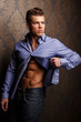 Fashion portrait of man in shirt showing his abs.