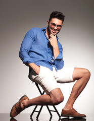 Poster - happy young man sitting on a chair