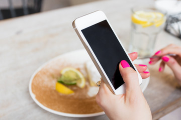 Woman using mobile phone in cafe