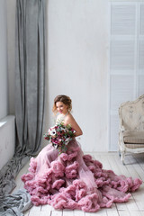 The beautiful woman posing in a wedding dress.