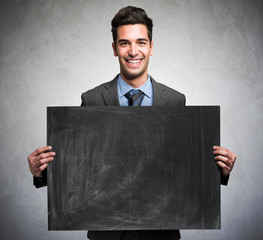 Smiling businessman holding a blackboard
