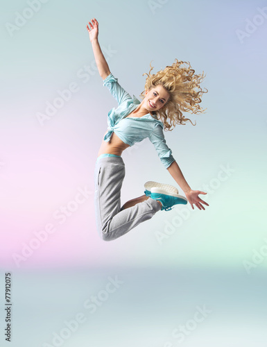 Fototapeta na wymiar Curly-haired athlete woman jumping and dancing
