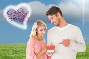 Poster - Attractive couple holding miniature house model