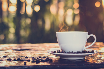 Hot coffee on old wood table with coffee beans- vintage style 