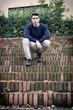 © theartofphoto - Handsome young man sitting outdoor on old brick stairs