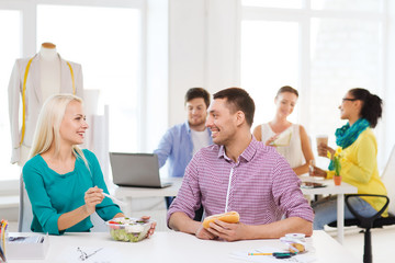 Poster - smiling fashion designers having lunch at office