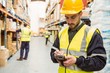 © WavebreakmediaMicro - Focused worker wearing yellow vest using handheld