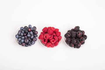 Wall Mural - Blackberries Blueberries and Raspberries in Cups on White