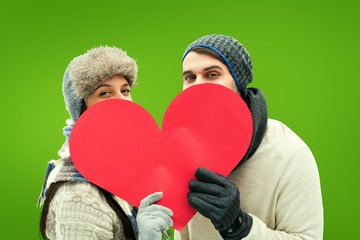 Poster - Attractive young couple in warm clothes holding red heart