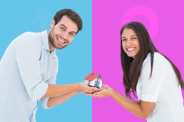 Poster - Composite image of attractive young couple holding a model house