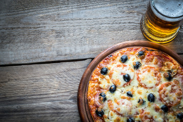 Wall Mural - Cooked pizza with a glass of beer