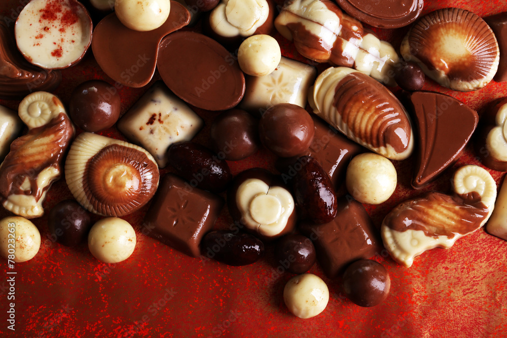 Different kinds of chocolates on red background