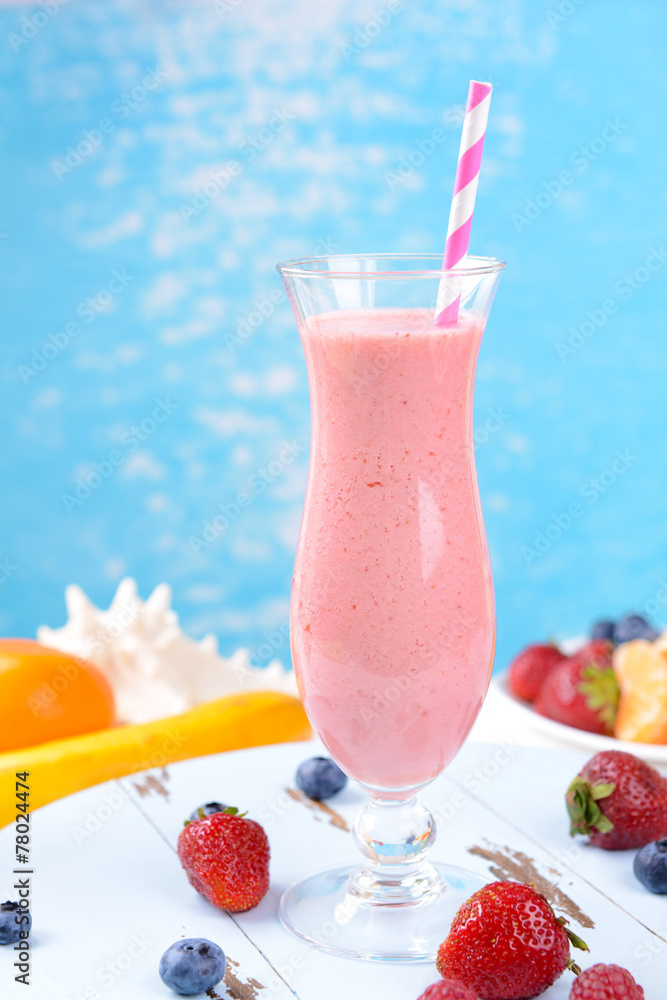 Delicious berry cocktail on table on water background