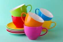 Colorful Cups And Saucers On Color Background