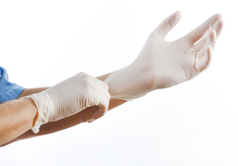 Doctor putting on sterile gloves isolated on white