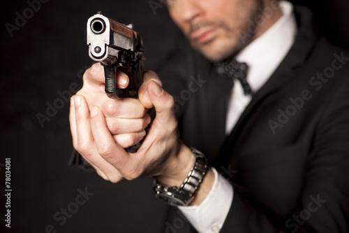 Fotografie, Tablou handsome man in a suit aim with a gun