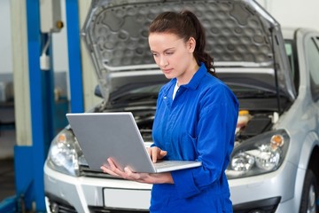 Wall Mural - Mechanic using laptop on car