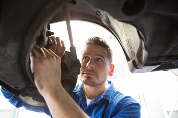 Wall Mural - Focused mechanic adjusting the wheel