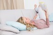 © WavebreakMediaMicro - Petty blonde lying on couch reading book