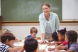© WavebreakMediaMicro - Teacher and pupils working at desk together