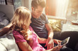 © Joshua Resnick - attractive couple using tablet together o nfuton h at home