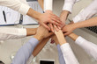 © Africa Studio - United hands of business team on workspace background top view