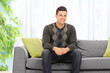 © Ljupco Smokovski - Young man posing seated on a sofa at home